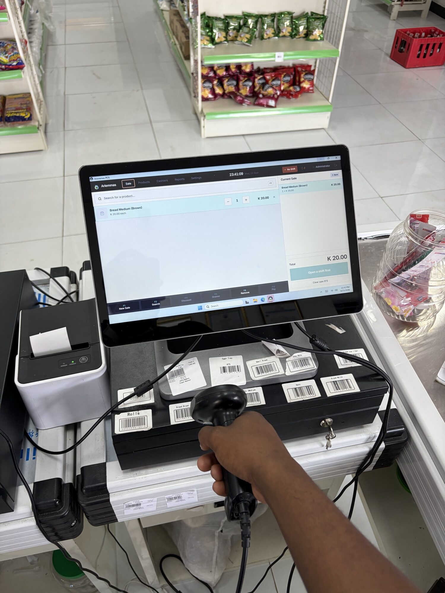 A Kasenti till with a barcode scanner, receipt printer and cash drawer on a shop counter